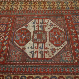 Close-up of a richly colored antique rug with geometric medallions by Rugs On Net