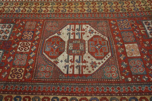 Close-up of a richly colored antique rug with geometric medallions by rugs on net