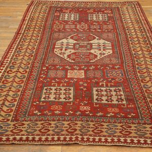 A long runner rug with geometric patterns in red, beige, and blue on a wooden floor by Rugs On Net. by Rugs On Net