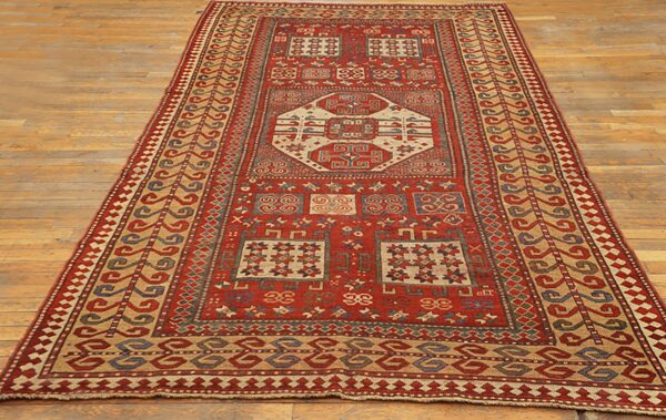A long runner rug with geometric patterns in red, beige, and blue on a wooden floor by rugs on net. By rugs on net