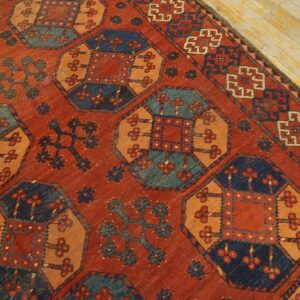 Close-up of a richly colored, antique rug with geometric motifs in red, orange, and blue by Rugs On Net