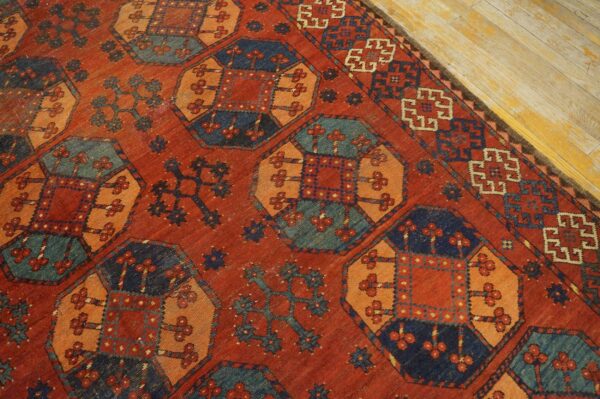 Close-up of a richly colored, antique rug with geometric motifs in red, orange, and blue by rugs on net