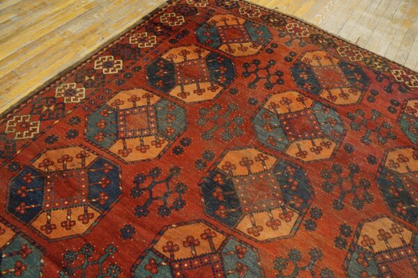 Close-up of a richly colored, geometric rug featuring red, orange, and dark blue motifs on a hardwood floor, by rugs on net