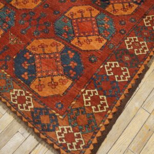 Close-up corner view of a richly colored rug with geometric patterns in red, orange, and blue, by Rugs On Net. by Rugs On Net