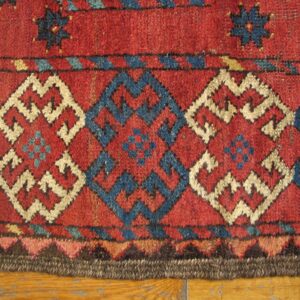Close-up of geometric patterns in red, blue, and cream on an antique rug by Rugs On Net. by Rugs On Net