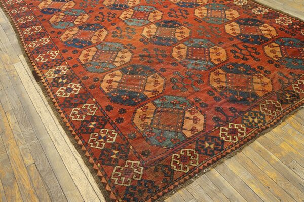 Close-up view of a richly colored, geometric rug with terracotta, blue, and orange tones, on a light wood floor by rugs on net