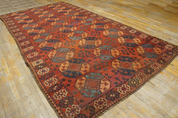 Close-up view of a richly colored, geometric patterned rug on a light wood floor by rugs on net