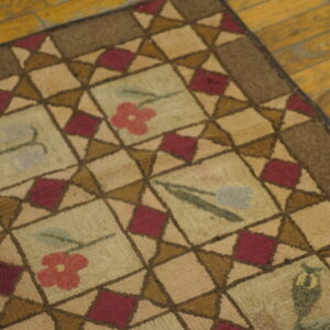 Close-up of a hooked rug with a geometric pattern and floral motifs, by Rugs On Net