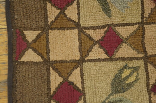 Close-up of the geometric and floral pattern on the hooked wool rug by rugs on net. By rugs on net
