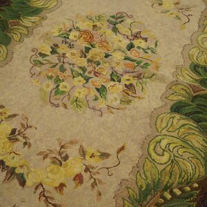 Close-up of a beige rug with yellow floral bouquets and green scrolling borders, by Rugs On Net