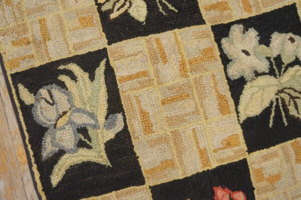 Close-up of a hooked rug with a checkerboard pattern featuring stylized flowers in black squares, by rugs on net
