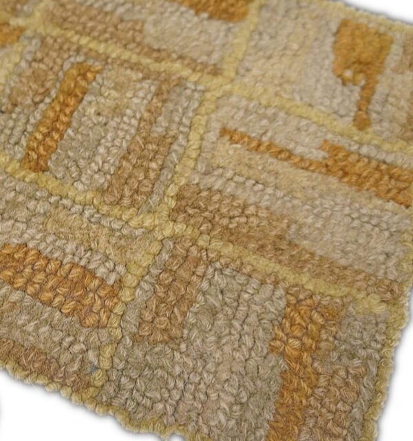 Close-up of a beige and gold geometric pattern on a textured rug by rugs on net