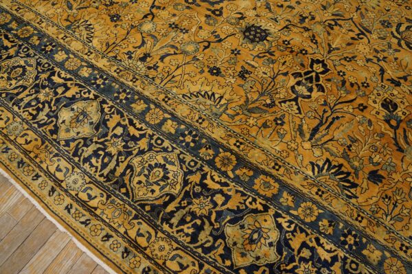 Close-up of a gold and navy floral patterned rug by rugs on net. By rugs on net