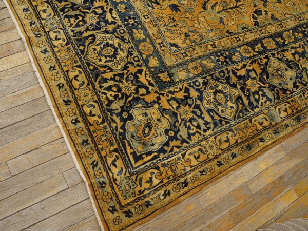 Close-up corner detail of a gold and navy blue traditional rug by rugs on net. By rugs on net