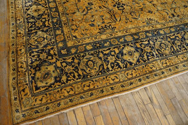 Close-up of a richly patterned gold and navy rug border by rugs on net. By rugs on net