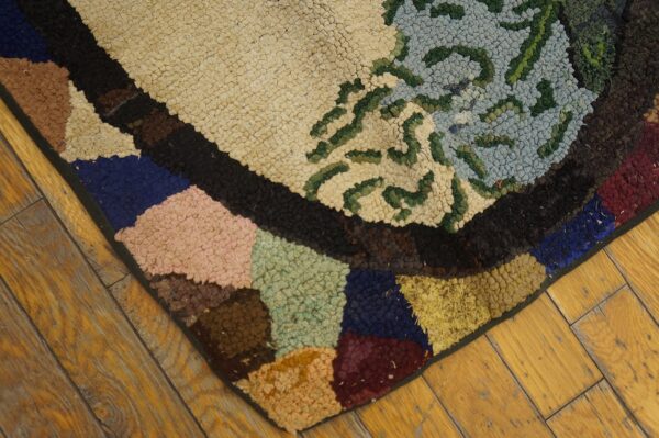 Close-up of a colorful hooked rug with abstract shapes on a wooden floor by rugs on net