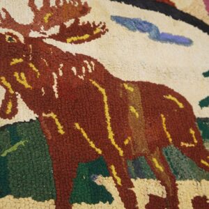 Close-up of a hooked rug featuring a large brown moose against a light background with green foliage, by Rugs On Net. by Rugs On Net