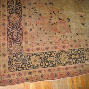Close-up corner detail of an antique rug with faded earth tones and dark blue floral borders by Rugs On Net. by Rugs On Net