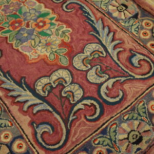 Close-up of a richly colored hook rug with floral and scrolling patterns in deep pink, blue, and multi-colored accents by Rugs On Net. by Rugs On Net