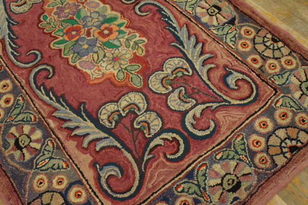Close-up of a richly colored hook rug with floral and scrolling patterns in deep pink, blue, and multi-colored accents by rugs on net. By rugs on net