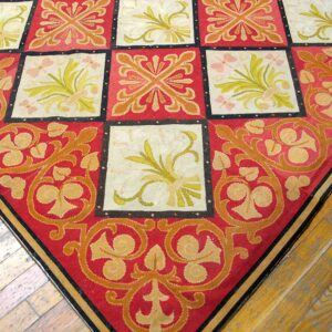 Close-up corner view of a red and cream needlepoint rug with a repeating square motif, by Rugs On Net