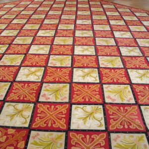 Close-up view of a large red and cream checkered rug with floral motifs, by Rugs On Net
