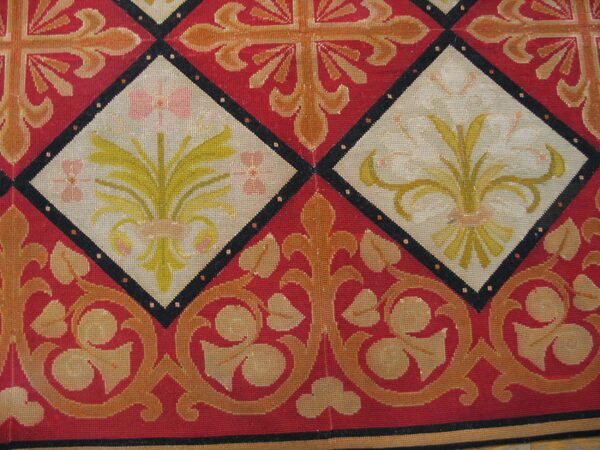 Close-up of a red and cream tapestry rug featuring diamond medallions with floral motifs, by rugs on net