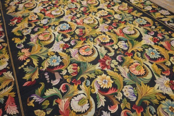 Close-up of a dark background rug featuring vibrant, dense floral and foliate patterns in yellow, red, blue, and green by rugs on net