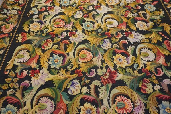 Close-up of a dark aubusson rug featuring vibrant floral and acanthus leaf motifs in gold, red, and blue hues by rugs on net. By rugs on net