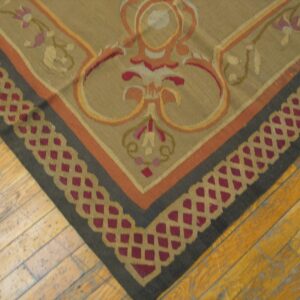 Close-up of a corner of a tapestry rug featuring beige, orange, and dark borders with a repeating geometric pattern by Rugs On Net. by Rugs On Net