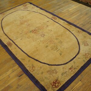 Oval yellow rug with faint floral pattern and purple border on wood floor by Rugs On Net