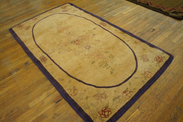 Oval yellow rug with faint floral pattern and purple border on wood floor by rugs on net