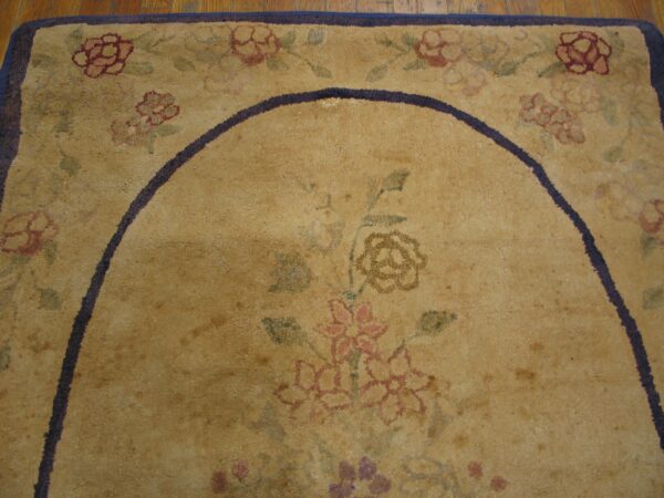 Close-up of an aged, tan floral rug with a dark border detail by rugs on net