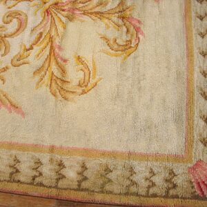 Close-up of a beige rug corner with gold and pink floral elements and a patterned border by Rugs On Net