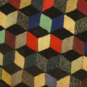 A textured, close-up view of the Geometric Cube Illusion Rug featuring a repeating pattern of multicolored, three-dimensional cubes in shades of red, blue, green, and beige on a black background by Rugs On Net