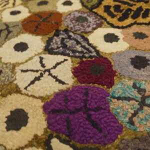Close-up of a colorful hooked rug with abstract floral shapes, by Rugs On Net