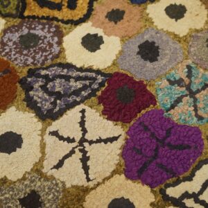 Close-up of a colorful hooked rug with abstract floral shapes in purple, red, cream, and brown by Rugs On Net. by Rugs On Net