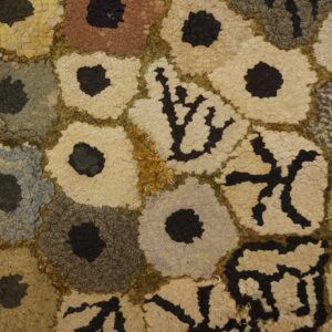 Close-up of a hooked rug with abstract floral shapes in muted earth tones, by Rugs On Net