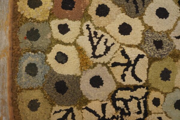 Close-up of a hooked rug with abstract floral shapes in muted earth tones, by rugs on net