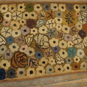 A close-up view of a colorful, folk-art style hooked rug featuring scattered floral and abstract shapes on a muted background, similar to the 'Scattered Blooms' rug by Rugs On Net. by Rugs On Net
