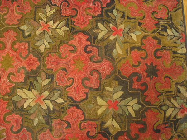 Close-up of a hooked rug featuring red paisley-like motifs against an olive and dark brown background by rugs on net. By rugs on net