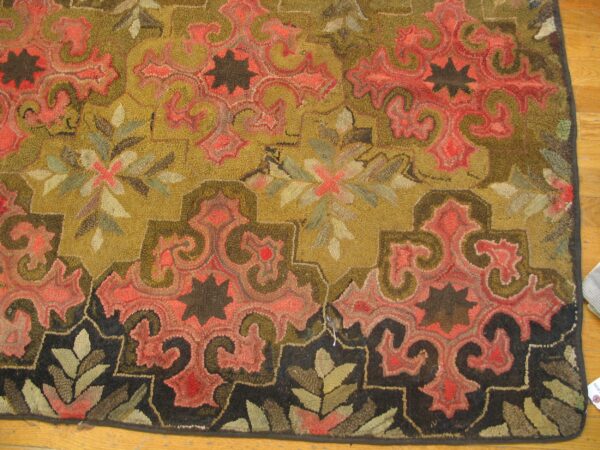 Close-up of a richly colored hooked rug featuring olive green and deep coral paisley motifs against a gold field, with a dark border by rugs on net. By rugs on net