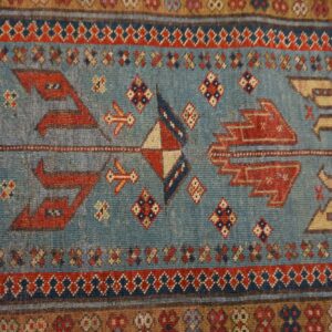 Close-up of a blue field with geometric red and tan motifs from the Tribal Runner Rug by Rugs On Net. by Rugs On Net