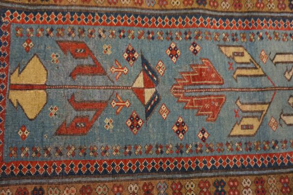 Close-up of a blue field with geometric red and tan motifs from the tribal runner rug by rugs on net. By rugs on net