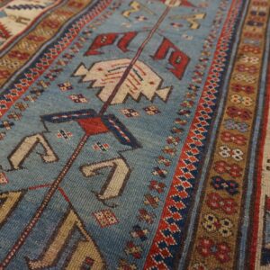 Close-up of a blue field rug with geometric patterns and borders by Rugs On Net