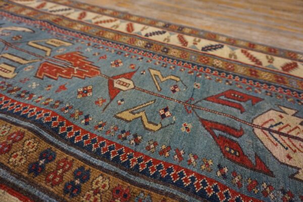 Close-up of a vintage blue rug with red and tan geometric motifs by rugs on net