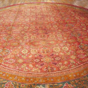 Close-up view of a richly colored, round Persian rug with intricate floral patterns in shades of red, orange, and blue, by Rugs On Net
