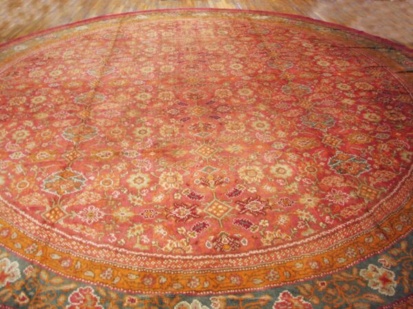 Close-up view of a richly colored, round persian rug with intricate floral patterns in shades of red, orange, and blue, by rugs on net