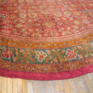 Close-up of a round rug with intricate floral patterns in red, orange, and green tones, by Rugs On Net. by Rugs On Net