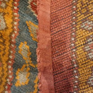 Close-up texture of a richly colored Berber rug with orange, blue, and yellow patterns by Rugs On Net
